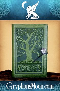 a green book with a white dragon on the cover and an intricate tree in the middle