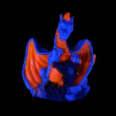 an orange and blue dragon figurine on a black background