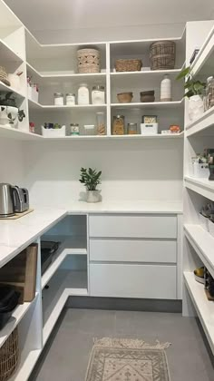 a kitchen with white cabinets and lots of shelves