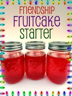 three jars filled with red liquid sitting on top of a white table next to colorful lights