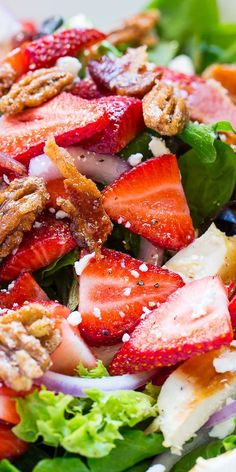 a salad with strawberries and pecans in it