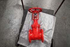 a red fire hydrant sitting on top of a piece of cloth