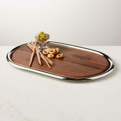 a tray with some snacks on it and olives in a glass bowl next to it