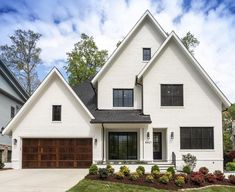 a large white house with two garages in the front yard