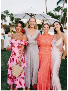 three beautiful women standing next to each other in front of palm trees and umbrellas