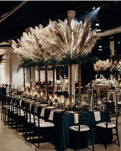 the tables are set with black linens and tall centerpieces filled with pamodia