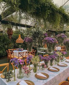 a table set up with plates and place settings for an outdoor dinner in the garden