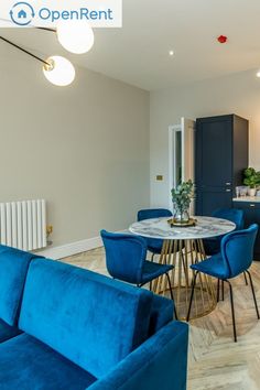 a blue couch and some chairs in a room