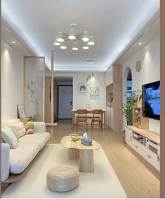 a living room filled with furniture and a flat screen tv on top of a wooden table