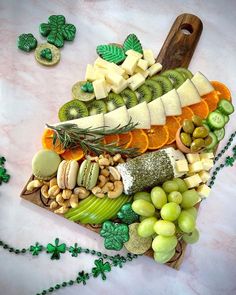 a platter filled with assorted fruits and vegetables next to shamrocks on a table