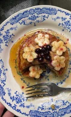 pancakes with bananas and blueberries are served on a plate, ready to be eaten