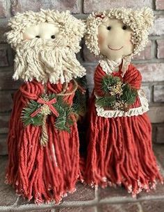 two red and white ceramic figurines are standing next to each other on a brick wall