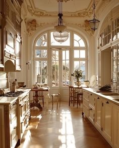 a kitchen with an arched ceiling and wooden floors, along with large windows that look out onto the outdoors