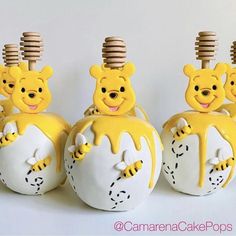 three yellow and white ceramic animals with wooden combs on their heads, one in the shape of an apple