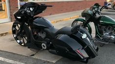 two motorcycles are parked on the side of the road