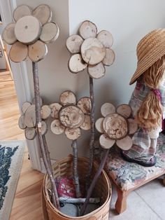 a basket filled with lots of logs sitting next to a tree stump sculpture on top of a wooden floor