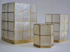 three white and gold vases sitting next to each other