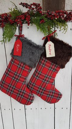 two christmas stockings hanging on a wall with red and black plaid stocking, one has a fur trim