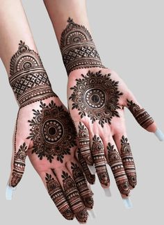 two hands with henna tattoos on them