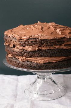 a close up of a cake on a plate with icing and chocolate frosting