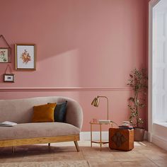 a living room with pink walls and furniture