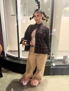 a woman standing in front of a display case with fake hair on top of her head