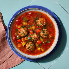 a bowl of soup with meatballs and vegetables