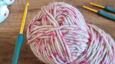 a ball of yarn and crochet hooks on a table