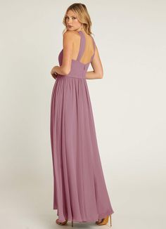 a woman in a long purple dress looking back at the camera with her hand on her hip