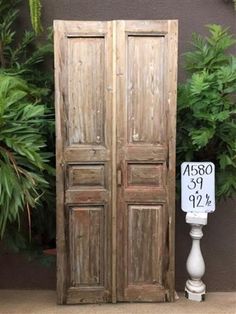 an old wooden double door next to a sign