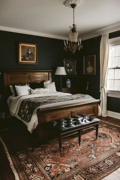 a bedroom with a large bed and chandelier hanging from the ceiling in front of a window