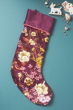 a purple christmas stocking sitting on top of a blue table next to other decorations