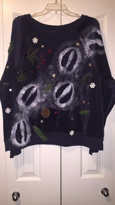 an ugly sweater hanging on a door with flowers and leaves all over it's surface