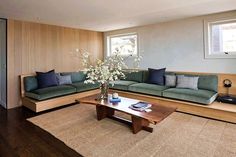 a living room with couches, coffee table and rugs on the wooden floor