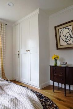 a bedroom with white walls and wooden floors