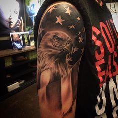 an eagle and american flag tattoo on the arm