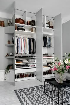 a living room filled with furniture and lots of closet space next to a white wall