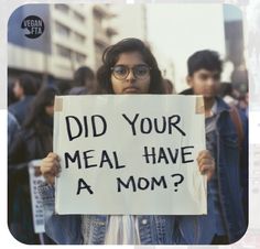 a woman holding a sign that says did your meal have a mom?