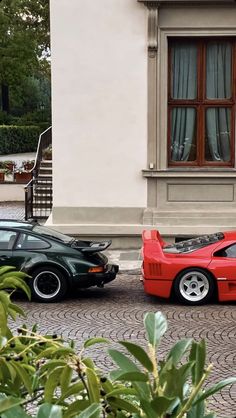 two cars parked next to each other in front of a building with windows and doors