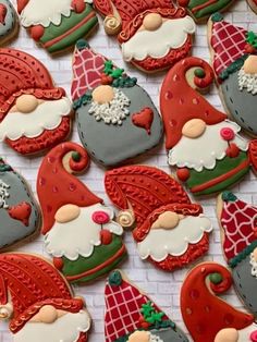 christmas cookies decorated with santa claus and other holiday decorations are displayed on a white brick wall