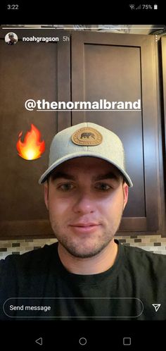 a man with a hat on taking a selfie in front of some cupboards