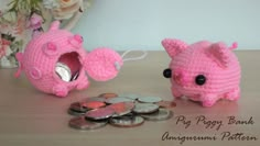 two pink crocheted piggy banks next to some coins