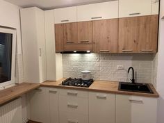 a kitchen with white cabinets and wooden counter tops