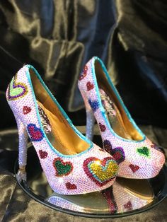 OVERVIEW:   Get groovy with these 60s Inspired Heels! Radiating retro vibes, these rainbow crystal high heels are a tribute to the colorful and carefree spirit of the 1960s. Featuring hand-drawn rainbow heart designs covered with individually placed faceted crystals, these sparkly shoes bring a bold and playful twist to any outfit. Whether for a retro-themed event, a party, or just adding some funk to your wardrobe, these heels are the ultimate statement of fun and individuality.  REASONS TO BUY Crystal High Heels, Crystal Heels, Cool Baby, Heart Hands Drawing, Rainbow Bright, Crystal Shoes, Rainbow Crystal, Bright Colours, Womens Heels