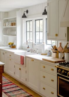 a large kitchen with white cabinets and wooden floors is featured in this post - op image