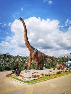 a large dinosaur statue in the middle of a parking lot