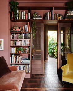 a living room filled with lots of books and furniture