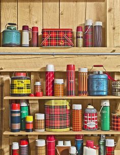 the shelves are filled with many different types of tins and containers on wooden shelves