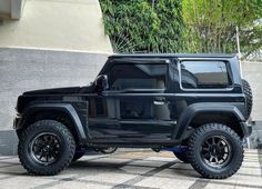 the black jeep is parked in front of a building