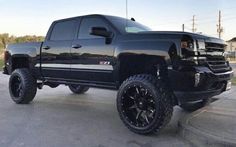 a large black truck parked in a parking lot